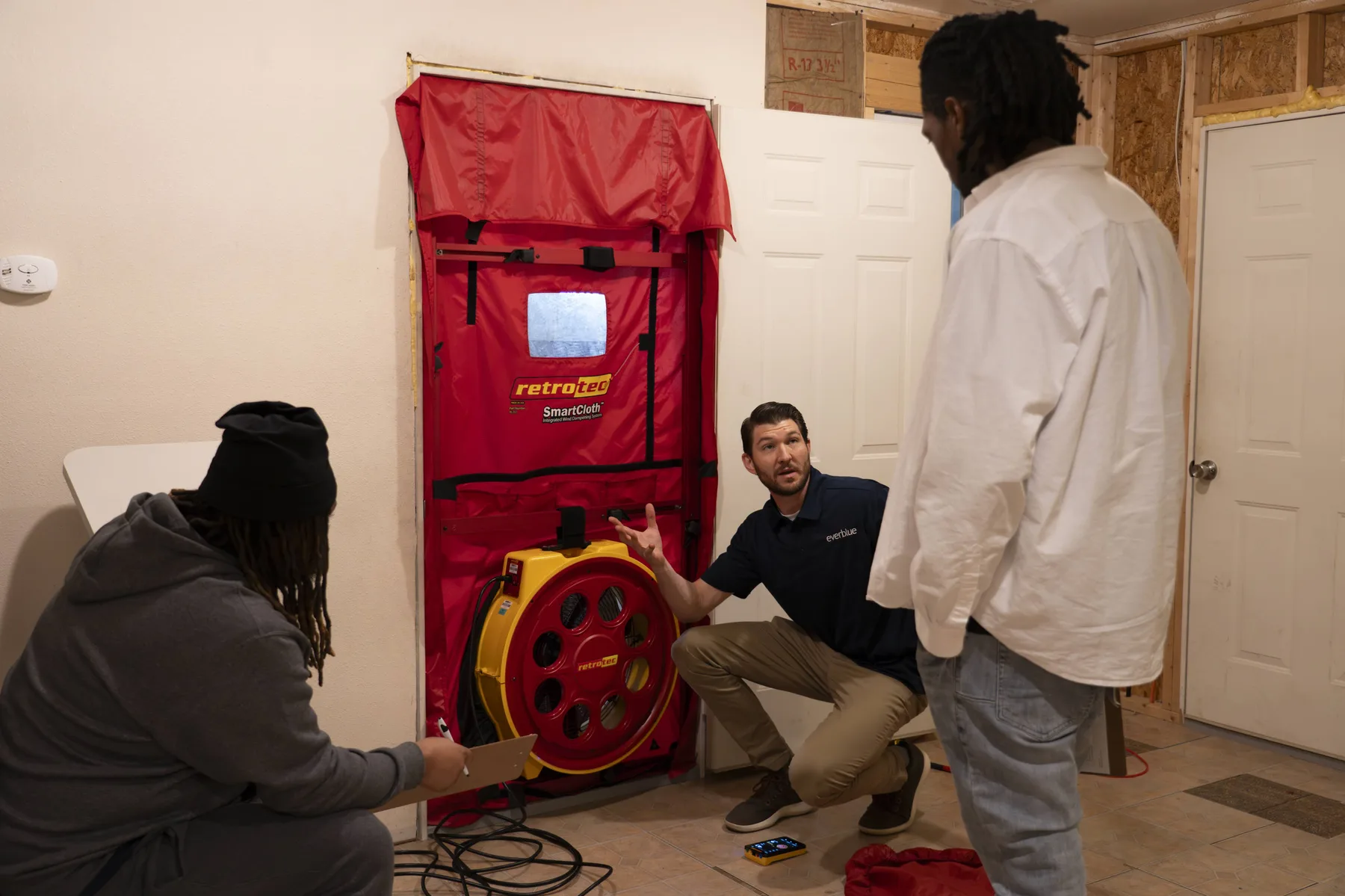 Everblue instructor demonstrating a blower door test to two trainees.